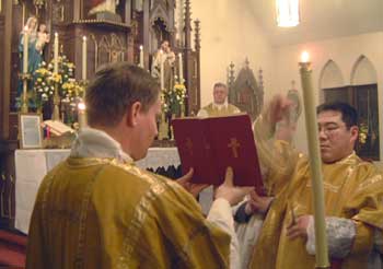 Fr. de l'Estourbeillon holds missal for Fr.  Sulzen