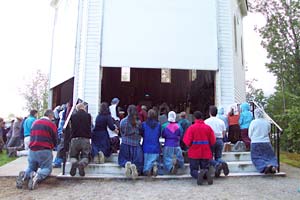 pilgrims kneel on outside steps