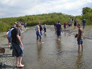 Pilgrims traverse creek