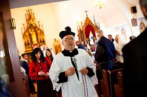 priest leaves church with rosary in hand