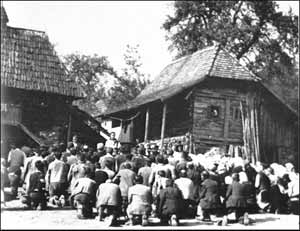 missionary praying with villagers