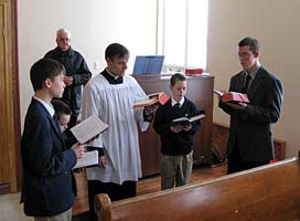 Father May leads the boys' schola 