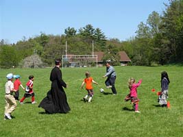 priest and children play soccer