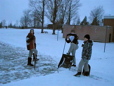 boys clearing off outdoor ice rink