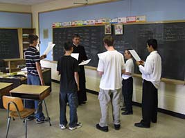 Fr May and boys in classroom