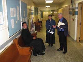 priest and teachers in hallway