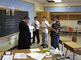 priest and boys practicing Gregorian Chant